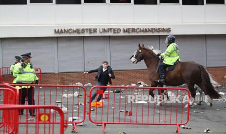 Penggemar Manchester United memprotes pemiliknya sebelum pertandingan Manchester United vs Liverpool dalam lanjutan laga Premier League di Old Trafford, Manchester, Inggris, Ahad (2/5). Penggemar Manchester United memegang suar sebagai protes terhadap pemiliknya sebelum Manchester United vs Liverpool.