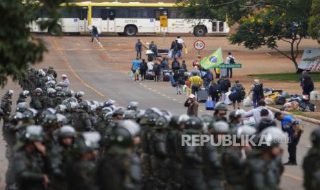 Polisi mengambil posisi saat pendukung mantan Presiden Brasil Jair Bolsonaro meninggalkan sebuah kamp di luar markas Angkatan Darat di Brasilia, Brasil, Senin, 9 Januari 2023. Sejak Bolsonaro kalah dalam pemilihan ulang dari Luiz Inácio Lula da Silva pada 30 Oktober, dia pendukung telah berkumpul di seluruh negeri menolak untuk mengakui kekalahan dan meminta angkatan bersenjata untuk campur tangan.