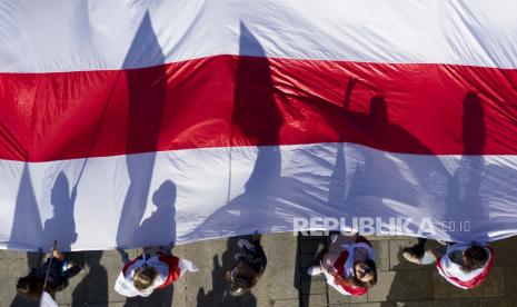  Aktivis Belarusia membuat bayang-bayang saat mereka membawa bendera Belarusia tua dalam unjuk rasa mendukung oposisi Belarus di Lapangan Kemerdekaan di Kyiv, Ukraina, Minggu, 20 September 2020. Para aktivis menuntut otoritas Belarusia untuk menghentikan represi politik di negara mereka.