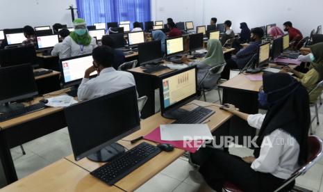 Petugas mengawasi  Ujian Tulis Berbasis Komputer (UTBK) Seleksi Bersama Masuk Perguruan Tinggi Negeri (SBMPTN) di kampus Universitas Bengkulu, Bengkulu, Senin (6/7/2020). Lembaga Tes Masuk Perguruan Tinggi menerapkan protokol kesehatan seperti menjaga jarak, pengecekan suhu tubuh, memakai masker atau pelindung wajah selama penyelenggaraan UTBK SBMPTN di Bengkulu yang diikuti oleh 7317 peserta. IDI Bengkulu merekomendasikan agar sekolah secara tatap muka dimulai pada Desember 2020, bukan sekarang.