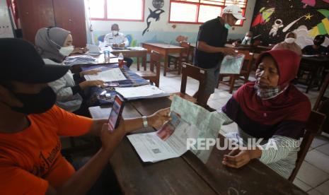 Petugas Kantor Pos Gaplek mendokumentasikan warga penerima bantuan sosial tunai (BST)  yang mulai disalurkan untuk warga Tangerang Selatan di Pondok Cabe, Tangerang Selatan, Rabu (28/7/2021). Pemerintah lewat Kantor Pos Indonesia mulai mencairkan dana BST warga Tangsel, Sebanyak 1876 warga Pondok Cabe Udik mendapatkan BST yang digabungkan selama dua bulan yakni sebesar Rp600 ribu. 