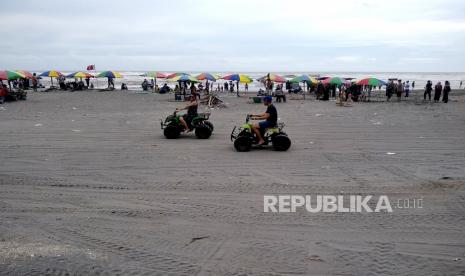 Wisatawan bermain motor ATV saat berlibur di Pantai Parangtritis, Bantul, Yogyakarta.