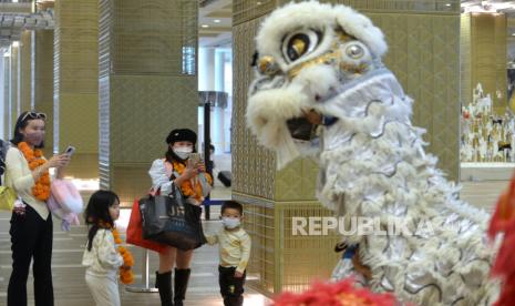 Wisatawan mancanegara asal China disambut kesenian Barongsai setibanya di Terminal Internasional Bandara Internasional I Gusti Ngurah Rai, Badung, Bali, Ahad (22/1/2023). 