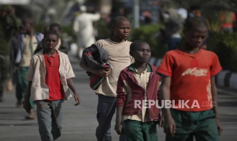  Siswa yang dibebaskan berjalan bersama dari bus yang mereka bawa dengan siswa lain setelah dibebaskan, di Kankara, Negara Bagian Katsina, Nigeria, 18 Desember 2020. Sekitar 300 anak sekolah Nigeria dibebaskan setelah diculik dari sekolah mereka di barat laut Nigeria dalam sebuah serangan yang diklaim oleh kelompok teroris Islam Boko Haram, meskipun belum jelas apakah masih banyak siswa yang masih berada di tangan penculik mereka.