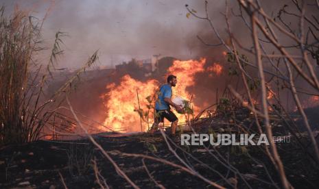 Sukarelawan berusaha memadamkan api saat terjadi kebakaran di Athena utara, Senin (12/8/2024).