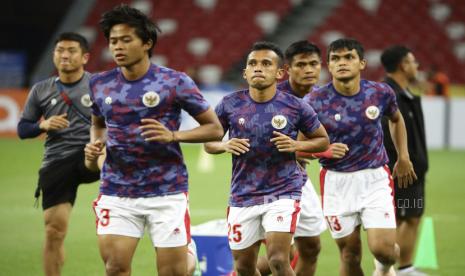 Irfan Jaya dari Indonesia, kedua kiri, melakukan pemanasan di lapangan jelang pertandingan leg pertama final Piala Suzuki AFF 2020 antara Indonesia dan Thailand di Singapura, Rabu, 29 Desember 2021.