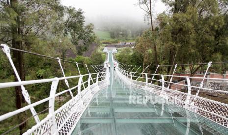 Pekerja berjalan di atas jembatan gantung kaca di Seruni Point Kawasan Strategis Pariwisata Nasional (KSPN) Bromo-Tengger-Semeru, Probolinggo, Jawa Timur. Rabu (15/2/2023). Kementerian PUPR membangun jembatan sepanjang 120 meter yang dapat menampung 100 orang tersebut bertujuan untuk menunjang perkembangan pariwisata dan perekonomian masyarakat di kawasan Bromo.