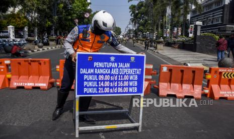 Petugas Dishub Kota Bandung membawa papan informasi saat penutupan Jalan Asia Afrika, Kota Bandung, Jumat (18/9). Pemerintah Kota Bandung menutup sejumlah ruas jalan diantaranya Jalan Asia Afrika - Tamblong, Jalan Otista - Suniaraja, Jalan Purnawarman - Martadinata, Jalan Merdeka - Riau dan Jalan Merdeka - Aceh pada pagi dan malam hari guna meminimalisir kerumunan pada masa Adaptasi Kebiasaan Baru (AKB) yang diperketat. Foto: Abdan Syakura/Republika