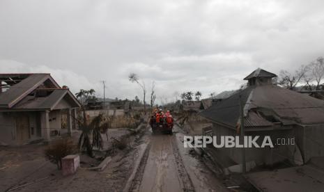 Sejumlah relawan melewati jalan berlumpur untuk melakukan evakuasi korban yang diduga masih tertimbun longsoran material awan panas di Dusun Curah Kobokan, Desa Supitarang, Kabupaten Lumajang, Senin (6/12). Dusun Curah Kobokan adalah salah satu wilayah yang terdampak cukup parah akibat erupsi Gunung Semeru. Hampir semua rumah warga di lokasi itu hancur.