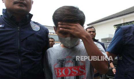 Polisi membawa AWK (24) tersangka pengancaman salah satu capres di Ditreskrimsus Polda Jatim, Jawa Timur, Rabu (17/1/2024). Subdit V Siber Ditreskrimsus Polda Jatim menangkap AWK atas kasus dugaan melakukan pengancaman akan menembak salah satu pasangan calon presiden Pemilu 2024 dalam komentarnya di salah satu akun media sosial. 