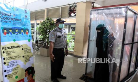 Pengunjung  memasuki bilik disinfektan yang terpasang di terminal Bungurasih, Sidoarjo, Jawa Timur, Jumat (27/3/2020). Bilik tersebut disediakan di pintu masuk ruang tunggu terminal yang wajib dilewati pengunjung untuk mencegah penyebaran Virus Corona (COVID-19) yang merupakan salah satu pintu masuk ke Kota Surabaya