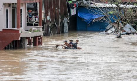 Anak laki-laki naik tabung melalui daerah pemukiman banjir di Medan, Sumatera Utara, (ilustrasi).