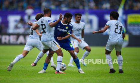 Gelandang Persib Bandung Riky Kambuaya berusaha melepaskan diri dari kepungan lawan pada laga antara Persib Bandung melawan Rans Nusantara FC di Stadion GBLA, Bandung, Ahad (4/9/2022). Laga berakhir dengan skor 2-1 untuk kemenangan Tim Persib Bandung.