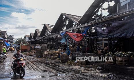 Warga melintas di depan deretan kios pascakebakaran di Pasar Induk Caringin, Kota Bandung, Kamis (10/11/2022). Kebakaran yang terjadi pada Kamis (10/11/2022) pukul 01.34 WIB tersebut menghanguskan sedikitnya 36 kios pedagang dan penyebab kebakaran masih dalam penyelidikan petugas terkait. 