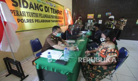 Warga yang terjaring Operasi Yustisi Pelanggar Protokol Kesehatan mengikuti sidang di tempat di kawasan Pogot, Surabaya, Jawa Timur, Rabu (16/9/2020). Puluhan orang yang tidak bermasker terjaring dalam operasi tersebut dan disanksi dengan membayar denda serta menyapu jalanan bagi yang tidak mampu membayar denda. 