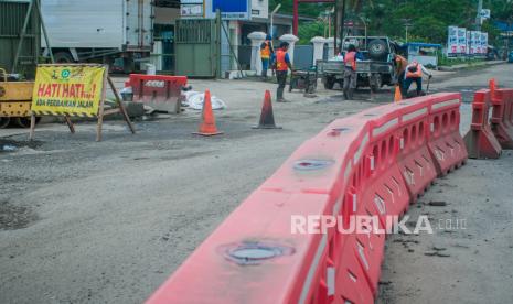 Pekerja menyelesaikan perbaikan jalan yang rusak  (ilustrasi)