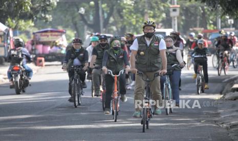 Gubernur Jawa Barat Ridwan Kamil mengikuti kegiatan bersepeda bersama pendiri Jabar Bergerak Atalia Praratya Ridwan Kamil dan pengurus Jabar Bergerak tingkat provinsi di Kota Bandung, Ahad (26/7). Dalam kegiatan tersebut dilakukan sosialisasi 3M, memakai masker, mencuci tangan dan menjaga jarak.