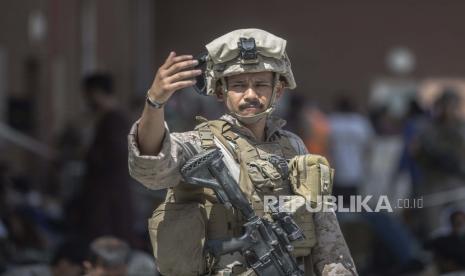 Dalam gambar yang disediakan oleh Korps Marinir AS, seorang Marinir dengan Komando Pusat Tanggap Krisis Udara-Ground Marinir Tujuan Khusus memandu keluarga selama evakuasi di Bandara Internasional Hamid Karzai di Kabul, Afghanistan, Senin, 23 Agustus 2021.