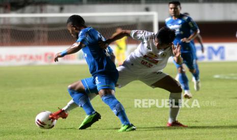 Penyerang PSS Saddam Gaffar berebut bola dengan penyerang Persib Freya Butuan pada pertandingan Semifinal Pertama Piala Menpora 2021 di Stadion Maguwoharjo, Sleman, Yogyakarta, Jumat (16/4) malam.