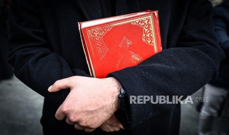 Seorang Muslim memeluk Alquran memprotes aksi Rasmus Paludan membakar Alquran.