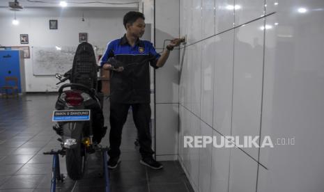 Siswa SMK mengisi daya baterai sepeda motor listrik di Bengkel Kelistrikan TBSM SMKN 8 Kota Bandung, Jalan Kliningan, Lengkong, Kota Bandung, Provinsi Jawa Barat, Selasa (14/2/2023). Siswa kelas XI dan XII jurusan Teknik Bisnis Sepeda Motor (TBSM) mengkonversikan motor berbahan bakar minyak ke tenaga listrik yang diberi nama Matric 8 (Matic Electric). Sepeda motor listrik tersebut memiliki daya 72 volt dan mampu menempuh jarak 50 kilometer hingga 60 kilometer dengan pengisian daya selama lima jam.