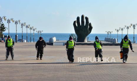  Petugas karantina mendisinfeksi sebuah alun-alun di Cape Homi, titik populer di mana matahari terbit dapat dilihat lebih awal daripada lokasi lain di Semenanjung Korea, di pantai Pohang di tenggara Korea Selatan, 22 Desember 2020, di tengah pandemi virus corona. Pemerintah kota Pohang mengatakan akan menutup alun-alun mulai 31 Desember hingga 01 Januari sebagai bagian dari upaya memerangi penyebaran penyakit virus korona baru (COVID-19).