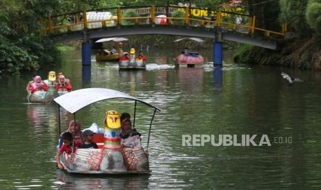 Wisatawan menaiki wahana sepeda air di Ekowisata Boonpring Andeman, Malang, Jawa Timur, Ahad (20/12/2020). Kawasan wisata berupa sumber air dan hutan bambu seluas 36,8 hektare yang pembangunannya menggunakan dana desa serta difasilitasi oleh Bank BNI tersebut dikelola oleh Badan Usaha Milik Desa (BUMDes) setempat sehingga kini mampu menghasilkan omzet hingga Rp.2,8 Miliar per tahun.  