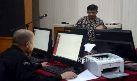 Komisioner KPU Idham Holik berbincang dengan Petugas KPU saat meninjau proses verifikasi berkas perbaikan dokumen persyaratan bakal calon anggota Dewan Perwakilan Rakyat oleh partai politik peserta pemilihan serentak tahun 2024 di Kantor KPU, Jakarta, Ahad (9/7/2023). Hari ini, merupakan hari terakhir pengajuan perbaikan dokumen persyaratan bakal calon anggota Dewan Perwakilan Rakyat oleh partai politik peserta pemilihan serentak tahun 2024. KPU telah membuka dan memberikan kesempatan bagi partai politik peserta pemilu 2024 mulai dari 26 Juni hingga 9 Juli untuk perbaikan dokumen persyaratan calon legislatif yang belum memenuhi syarat.  