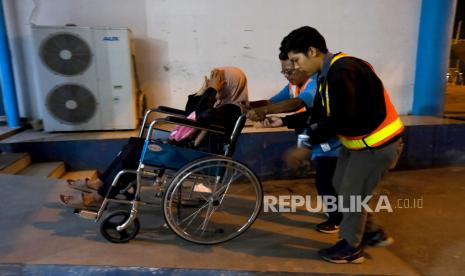 Dua petugas membantu pemudik disabilitas naik ke KM Bukit Raya rute Pontianak-Surabaya di Pelabuhan Dwikora, Pontianak, Kalbar, Ahad (16/4/2023). Sebanyak 1.408 pemudik diberangkatkan dari Pontianak menuju Surabaya pada H-6 Idul Fitri 1444 Hijriah. 