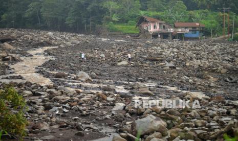 Warga menyeberangi sungai yang debit airnya meningkat di Nagari Sungai Jambu, Tanah Datar, Sumatera Barat, Senin (20/5/2024). BMKG mengingatkan masyarakat di wilayah di sekitar Gunung Marapi agar tetap waspada karena curah hujan masih tinggi dan masih berpotensi banjir bandang susulan yang berasal dari 25 titik hulu sungai. 