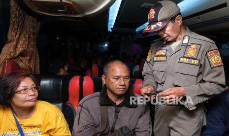 Anggota Satpol PP memeriksa kartu tanda penduduk (KTP) penumpang bus AKAP saat sidak pada arus balik Lebaran. Legislator minta Pemprov DKI melakukan pendekatan komprehensif terhadap pendatang.