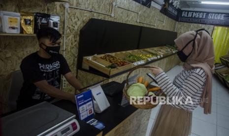 Pengunjung bertransaksi untuk membayar sejumlah sayuran di Alifmart Store, Bandung, Jawa Barat, Kamis (24/6/2021). Alifmart Store menjual kurang lebih 64 jenis komoditas sayuran hasil pertanian dari kelompok tani pondok pesantren yang ada di Jawa Barat sebagai salah satu sektor usaha pemberdayaan dan peningkatan ekonomi. 