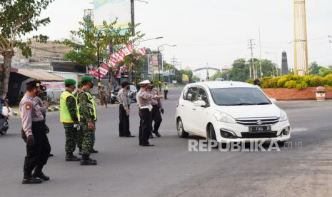 Petugas gabungan menghentikan mobil berplat nomor luar daerah saat penyekatan dalam rangka larangan mudik di Kota Madiun, Jawa Timur, Selasa (4/5/2021). Penyekatan yang dilakukan petugas gabungan TNI, Polri, Satpol PP dan Badan Penanggulanan Bencana Daerah (BPBD) itu dimaksudkan untuk mengantisipasi pemudik masuk wilayah Kota Madiun guna mencegah penularan COVID-19. 