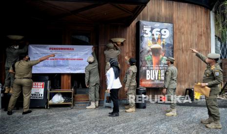 Petugas Satpol PP bersama Dinas Pariwisata dan Ekonomi Kreatif, serta TNI  melakukan penyegelan di salah satu bar-resto Holywings di Jakarta, Selasa (28/6/2022). Pakar sebut dalang utama promo miras Hollywings catut Muhammad-Maria harus ditangkap.