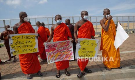  Para biksu Buddha Sri Lanka yang pro-pemerintah memegang plakat selama protes di luar kantor presiden meminta pemerintah untuk tidak meninjau kebijakan kremasi wajib bagi korban COVID-19 Muslim, di Kolombo, Sri Lanka, Senin, 28 Desember 2020. 