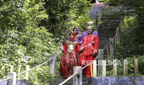 Sejumlah pemuda dan pemudi mengenakan pakaian adat Gorontalo pada atraksi budaya di Benteng Otanaha, Dembe Satu, Kota Gorontalo, Gorontalo, Rabu (22/12/2021). Masyarakat Kelurahan Dembe Satu meluncurkan Komunitas Industri Pariwisata, Pelaku Ekonomi Kreatif dan slogan promosi wisata untuk meningkatkan perekonomian masyarakat dengan memanfaatkan sumber daya manusia dan alam. 