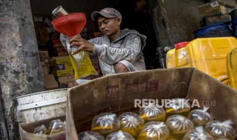 Pekerja menuangkan minyak goreng curah ke dalam plastik di salah satu kios sembako (ilustrasi), Asosiasi Pedagang Pasar Indonesia (APPSI) menyarankan agar pendistribusian minyak goreng curah bersubsidi dapat melalui Badan Usaha Milik Negara (BUMN). 