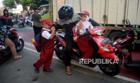 Orangtua murid mengantar anaknya ke sekolah di SD Negeri Anyelir 1 Depok ,Jawa Barat, senin (17/7/2023). Wali Kota Depok Mohammad Idris mengeluarkan surat edaran yang mengatur tentang hari pertama masuk sekolah. Salah satu poinnya yaitu mengimbau agar seluruh orang tua bisa mengantar anaknya pada hari pertama masuk sekolah. Selain itu juga memberikan kompensasi waktu kepada ASN di Lingkungan Pemerintah Daerah Kota Depok untuk mengantar putra dan putrinya ke sekolah. Hal ini bertujuan untuk mendukung implementasi Depok sebagai Kota Layak Anak.