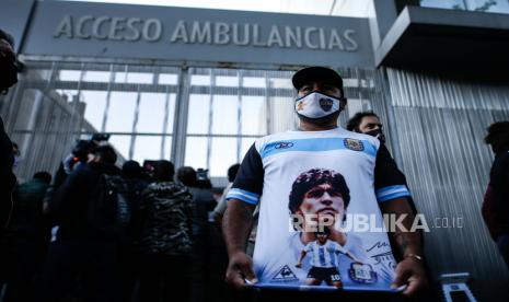  Seorang pria menunjukkan kemeja yang mengacu pada mantan pesepak bola dan pelatih Argentina Diego Armando Maradona, yang memasuki klinik Olivos, di provinsi Buenos Aires, Argentina, 03 November 2020. Maradona dipindahkan dari sebuah klinik di kota La Plata ke klinik lain di Olivos (provinsi Buenos Aires), di mana ia tiba di tengah tangisan dukungan dan ungkapan kasih sayang, untuk menjalani operasi hematoma subdural.