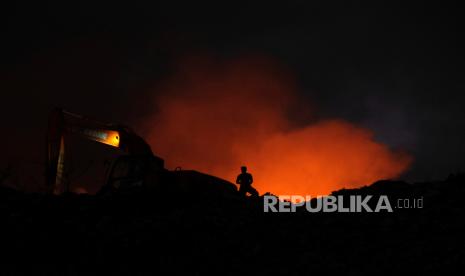 Petugas berupaya memadamkan api yang terus menjalar dengan menggunakan alat berat saat terjadi kebakaran sampah di Tempat Pembuangan Akhir (TPA) Regional Sarbagita Suwung, Denpasar, Bali, Rabu (8/5/2024). Kebakaran yang terjadi sekitar pukul 15.30 Wita tersebut masih dalam penanganan tim gabungan BPBD dengan mengerahkan 13 unit mobil pemadam kebakaran dan empat unit alat berat. 