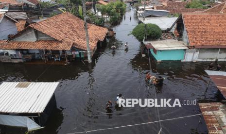 Foto udara warga melintasi kawasan pemukiman yang terendam banjir di Pasirkratonkramat, Kota Pekalongan, Jawa Tengah.