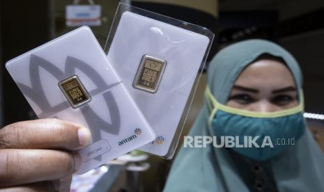 Pramuniaga menunjukkan emas batangan di Cikini Gold Center, Jakarta. Harga emas dari PT Antam, yang dipantau dari laman Logam Mulia, anjlok Rp 10 ribu menjadi Rp 924 ribu per gram pada Selasa (19/5). 