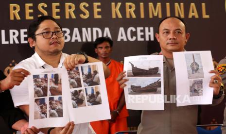 Kapolresta Banda Aceh Kombes Pol Fahmi Irwan Ramli (kanan) didampingi Kasat Reskrim Polresta Banda Aceh Kompol Fadhillah Aditya Pratama memperlihatkan barang bukti foto penyerahan uang dan kapal yang mengangkut pengungsi Rohingya saat rilis kasus penyuludupan manusia di Banda Aceh, Aceh, Senin (18/12/2023). Polresta Banda Aceh menetapkan imigran etnik Rohingya Muhammad Amin (35) sebagai tersangka yang menyeludupkan 136 orang pengungsi Rohingya penghuni kamp penampungan Coxs Bazar Bangladesh ke Desa Lamreh, Kabupaten Aceh Besar. 