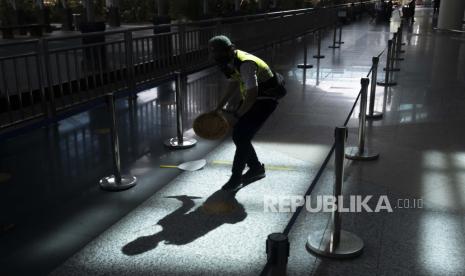  Seorang pekerja menempelkan tanda jarak fisik di area kedatangan internasional selama pembukaan bandara Internasional Ngurah Rai di Bali, Indonesia, 14 Oktober 2021. 