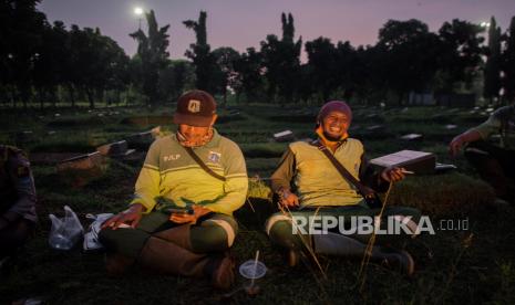 Petugas melepas lelah sambil menanti tugas selanjutnya di area TPU Pondok Ranggon, Jakarta. Sebanyak 115 penggali makam TPU Pondok Ranggon dapat perpanjangan SIM gratis. Ilustrasi.