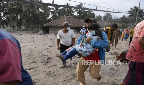 Warga berlarian di atas timbunan material guguran awan panas Gunung Semeru saat terdengar suara gemuruh dari Gunung Semeru di Desa Sumber Wuluh, Lumajang, Jawa Timur, Minggu (5/12/2021). Akibat awan panas guguran Gunung Semeru tersebut puluhan rumah warga rusak dan ratusan warga mengungsi. ANTARA FOTO/Zabur Karuru/pras.