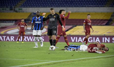 Pemain Inter Milan Victor Moses (kiri)  tergelatak di tanah setelah diganjal oleh pemain Roma Leonardo Spinazzola (kanan) pada pertandingan sepak bola Serie A Italia antara AS Roma dan FC Inter di stadion Olimpico di Roma, Italia, Ahad (19/7/2020).