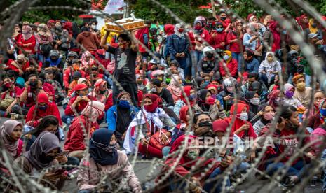 Massa berkerumun tanpa menjaga jarak fisik protokol kesehatan saat mengikuti aksi penolakan terhadap UU Cipta Kerja Omnibus Law di depan kompleks DPRD Jateng, Semarang, Jawa Tengah, Senin (12/10). Pemerintah memprediksi tren penambahan kasus positif Covid-19 akan melonjak dalam dua sampai tiga pekan mendatang. 