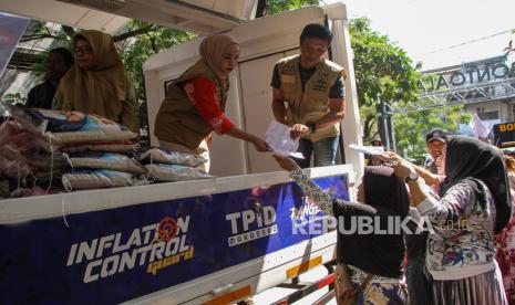 Officers serve citizens who buy food packages at a cheap market in Makassar, South Sulawesi, Thursday (13/6/2024).