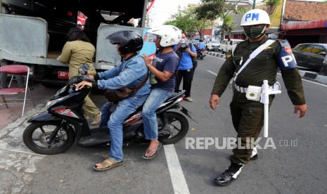 Petugas gabungan dari Gugus Tugas Penanganan Covid-19 melakukan razia masker di kawasan Pasar Beringharjo, Yogyakarta, Selasa (11/8). Pemkot Yogyakarta menggalakkan kembali himbauan penggunaan masker masyarakat. Untuk mengingatkan salah satunya dengan melakukan razia dan memberikan penyuluhan. Namun, tidak diberlakukan denda bagi pengendara bermotor yang tidak menggunakan masker.